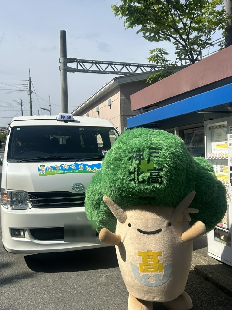 からとんくるりんバスの車両と、頭に「神戸北高」と書かれたキャラクター（2025年5月1日の出発式）